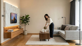Warm neutral Singapore living room with grey sofa, walnut coffee table and wood TV console