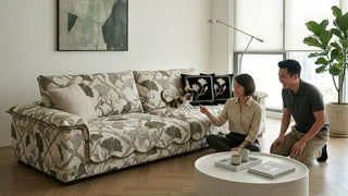 Couple playing with a cat on a cream sofa with waterproof slipcover