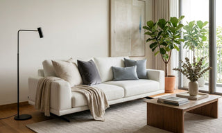 White sofa in a bright Singapore living room with neutral cushions, indoor plants, and wooden coffee table.