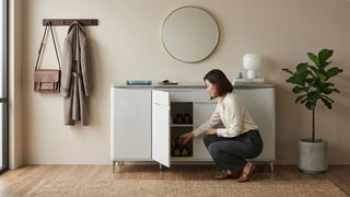 Woman organising shoes inside a white storage cabinet in a compact Singapore entryway