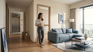 Woman measuring doorway and access path in a 1-bedroom condo before furniture delivery in Singapore.