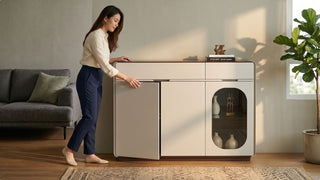 Woman opening a cream living room cabinet with closed storage and glass display section in a modern Singapore home