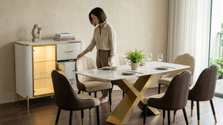 Woman opening a modern white sideboard beside a marble dining table in a bright Singapore dining room
