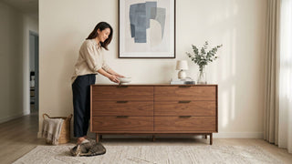 Wooden drawer cabinet styled in a Singapore bedroom with warm lighting, neutral decor, and a woman arranging items on top.