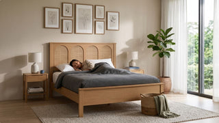 Wooden queen bed frame with rattan headboard, matching bedside tables, wall art, and cosy bedding in a modern Singapore bedroom
