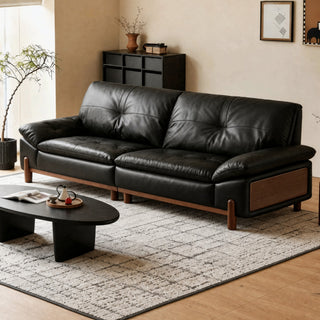 Black leather sofa with a solid rubberwood base in a living room