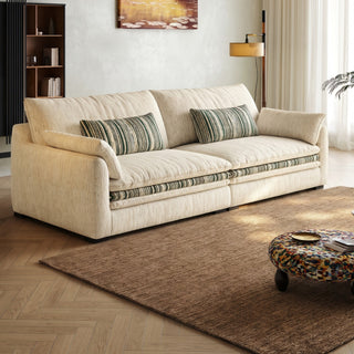 Cream chenille sofa with green-striped trim in a living room