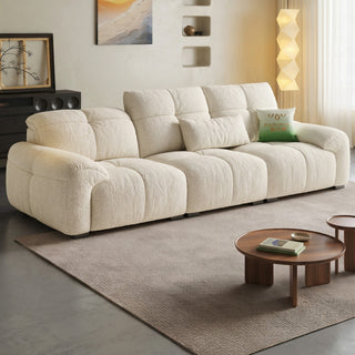 Cream lamb-fleece sofa with plump tufted cushions