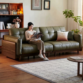 Olive-green leather sofa in a solid wood frame