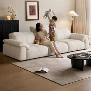 Cream fabric sofa with tall back cushions in a living room