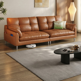 Tan leather sofa on raised legs in a living room