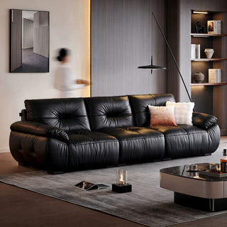 Black hand-pleated leather sofa in a living room