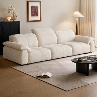 Cream fabric sofa with tall back cushions in a living room