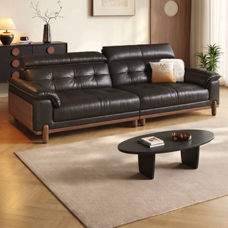Black leather sofa on a wooden base in a living room